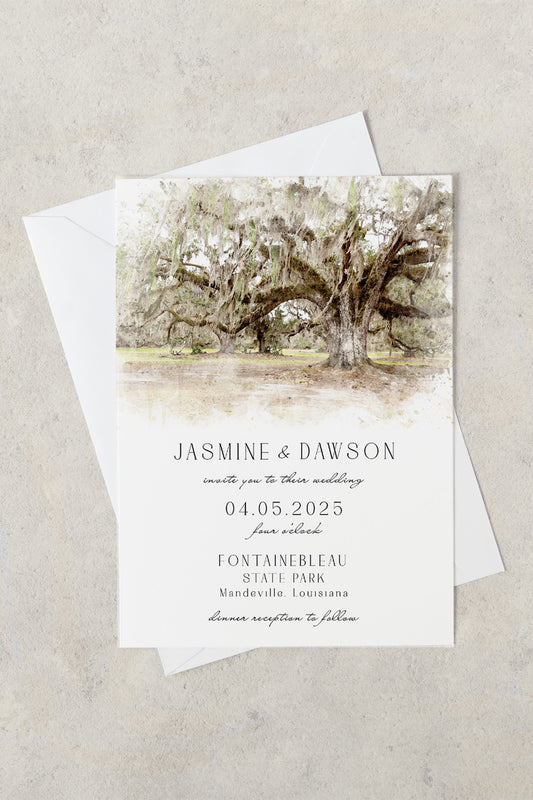 A wedding invitation card with an envelope, featuring a watercolor illustration of an oak tree and text inviting to a wedding at Fontainebleau State Park.