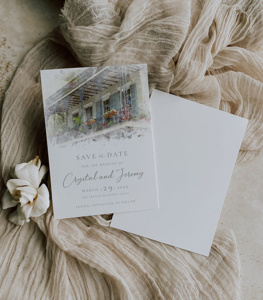 New Orleans save the date with a watercolor image of a grey wrought iron balcony in the French Quarter and grey writing.