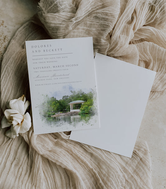 New Orleans wedding save the date featuring my very own watercolor image of the Newman Bandstand from across the lagoon. Script and serif fonts in grey complete the card.