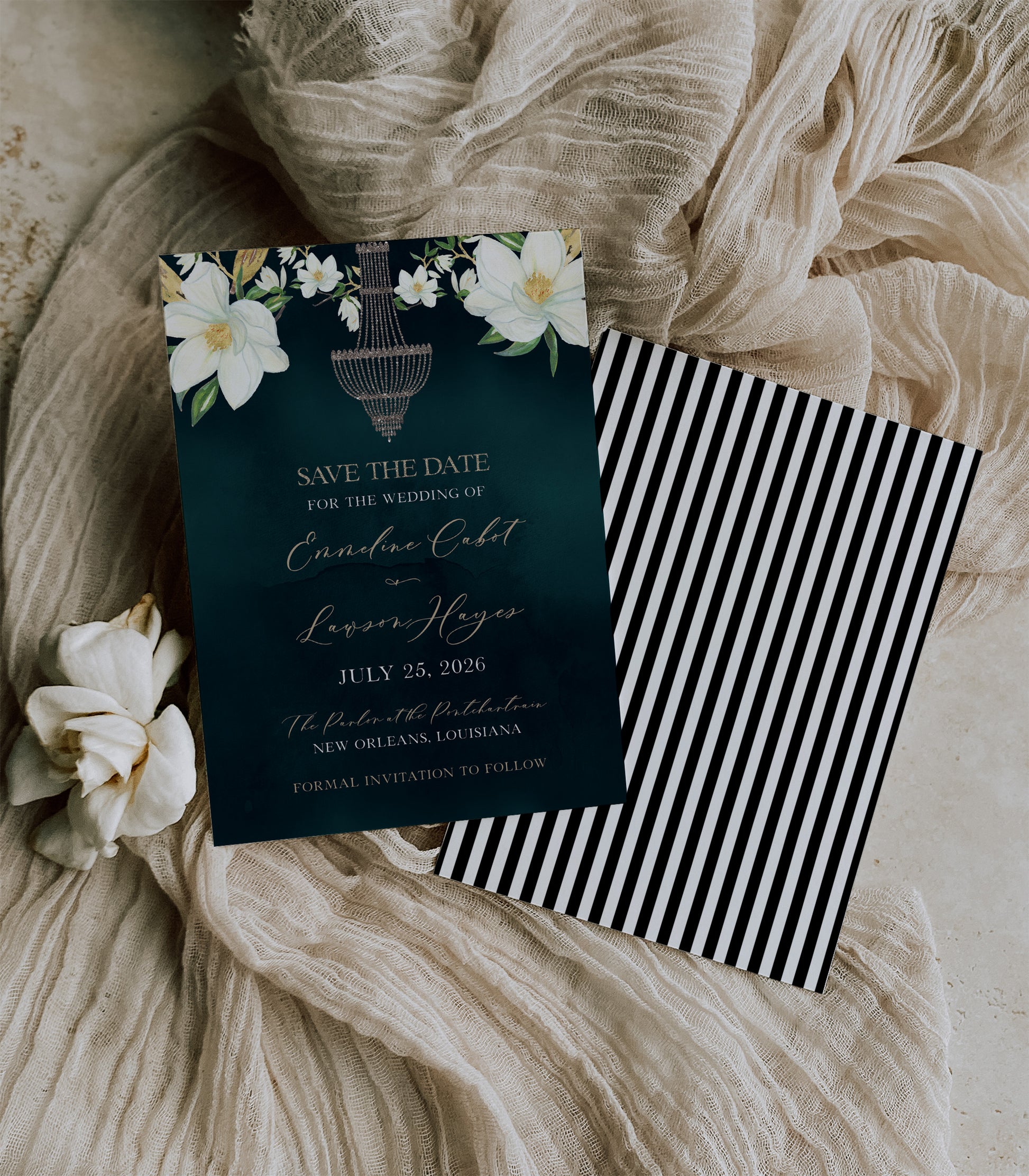 Dark green wedding save the date card with big magnolia's in the top corners and sparkle chandelier in the center. The back is black and white striped to resemble The Parlor's sign on the front of the building.