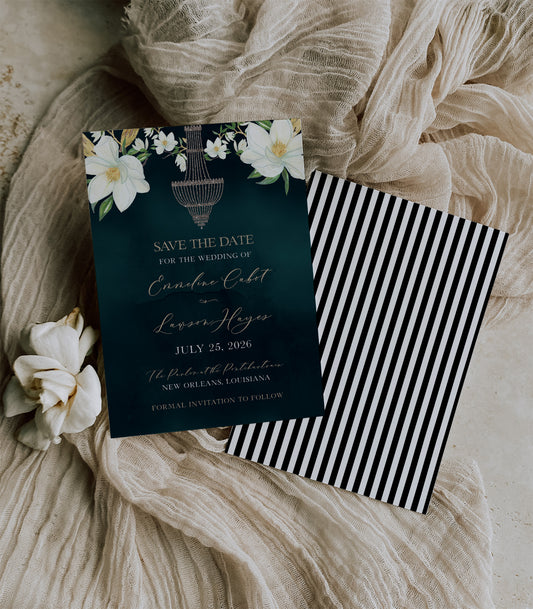 Dark green wedding save the date card with big magnolia's in the top corners and sparkle chandelier in the center. The back is black and white striped to resemble The Parlor's sign on the front of the building.